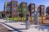 Modern apartment complex with eco-friendly electric vehicle charging stations, surrounded by lush landscaping and contemporary architecture.