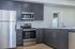 Modern kitchen with sleek stainless steel appliances, dark wood cabinets, and elegant countertops.