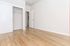 Bright and inviting bedroom with elegant wood flooring, spacious closet, and a clean modern design.