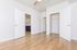 Modern spacious room with elegant hardwood flooring, multiple open doors, and a ceiling fan, offering versatility and comfort.