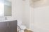 Bright and modern bathroom featuring sleek vanity, polished fixtures, and inviting bathtub.