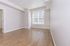 Bright, spacious room featuring elegant wood flooring and large windows, perfect for a cozy living space.
