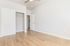 Bright and inviting bedroom with sleek wooden flooring and a spacious built-in closet, ideal for modern living.