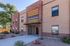 Modern brick apartment building exterior with lush landscaping and inviting entrance at Mesa Residences.