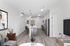 Modern open-concept apartment with sleek kitchen island, stainless steel appliances, and stylish living area featuring contemporary artwork.