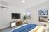 Bright and modern bedroom with large windows, stylish furnishings, and a cozy ambiance, perfect for relaxation.