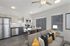 Modern apartment interior with open-concept living area, stylish kitchen, and cozy seating adorned with vibrant cushions.