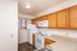 Inviting kitchen with warm wooden cabinets, modern white appliances, and ample countertop space.