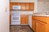 Modern kitchen with sleek wooden cabinetry, white appliances, and elegant countertops offering a bright and functional cooking space.