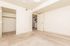 Inviting bedroom with plush carpet, ample natural light, and a spacious closet, leading to a modern open-plan living area.