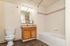 Bright and modern bathroom with elegant wood flooring, a sleek vanity, and a pristine bathtub for a serene bath retreat.