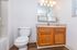 Bright and inviting bathroom featuring a modern sink, classic wooden cabinetry, and elegant lighting.