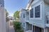 Charming light blue two-story home with white trim, featuring a quaint balcony and surrounded by lush greenery, ideal for serene living.