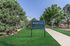 Inviting exterior of West Hill Apartments featuring lush green lawns and mature trees, exuding a welcoming and serene ambiance.