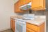 Bright kitchen with sleek white stove, ample oak cabinetry, and spacious countertops, ideal for culinary adventures.