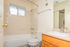 Bright and elegant bathroom with a modern tub, sleek fixtures, and a spacious vanity mirror, offering a tranquil retreat.