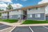 Charming apartment building with fresh paint and modern design, nestled in a serene neighborhood. Ample parking and lush green lawns enhance the inviting exterior.