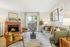 Inviting living room with a cozy brick fireplace, stylish seating, and vibrant decor, drenched in natural light through large sliding doors.