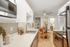 Sleek modern kitchen with stainless steel appliances, chic white cabinetry, and a cozy dining nook featuring stylish wooden chairs.
