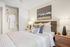 Chic and cozy bedroom with plush bedding, modern decor, and ample closet space featuring a luxurious robe.