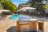 Inviting apartment complex pool area with modern grill station, poolside lounge chairs under striped umbrellas, and lush greenery, perfect for outdoor relaxation.