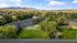 Beautiful aerial view of a sprawling apartment complex surrounded by lush greenery and scenic mountains, offering a peaceful and picturesque living environment.