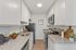 Chic and modern kitchen with sleek white cabinetry, elegant granite countertops, and stainless steel appliances, offering a sophisticated and functional space.