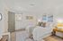 Inviting bedroom featuring a cozy bed adorned with elegant pillows, warm lighting, and tasteful artwork on the walls.
