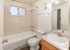 Bright and inviting bathroom featuring a modern bathtub, sleek vanity, and elegant tile detailing.