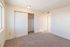 Inviting bedroom with plush carpeting, ample closet space, and natural light accentuating a fresh, neutral palette.
