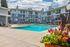 Inviting apartment complex with a sparkling outdoor pool and vibrant flower arrangements, perfect for relaxation and leisure.