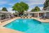 Inviting outdoor swimming pool surrounded by lounge chairs and lush greenery, perfect for relaxation and enjoyment.