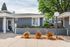 Charming apartment exterior with vibrant flower beds and welcoming entrance, surrounded by lush greenery.