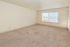 Bright, spacious room with plush carpet, large window, and abundant natural light, ideal for a cozy living area.