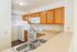 Charming kitchen with elegant wooden cabinetry, modern appliances, and a sleek double sink for a stylish culinary experience.