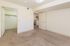 Bright and spacious bedroom with plush carpeting, featuring a walk-in closet and an inviting open doorway.
