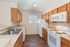 Inviting kitchen with sleek countertops, warm wooden cabinetry, and modern appliances, offering a cozy and functional cooking space.