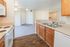 Inviting open-concept kitchen and living area featuring elegant wooden cabinetry, sleek countertops, and modern appliances, perfect for comfortable living.