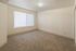 Bright and inviting empty room featuring plush carpeting, large window with blinds, and neutral tones perfect for personalization.