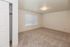 Bright, spacious bedroom with plush carpet, large window, and ample closet space.