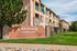 Beautiful apartment complex with brick accents and lush greenery, featuring Creekside at Norwood sign for affordable apartment homes.