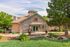 Charming stone-fronted apartment building surrounded by lush greenery and vibrant flower beds.