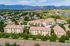 Charming apartment community nestled in a scenic mountain backdrop, featuring modern architecture surrounded by lush greenery.