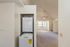 Bright and airy apartment featuring a high ceiling, plush carpeted floors, and an in-unit laundry area.