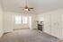 Bright living room with vaulted ceiling, cozy fireplace, and elegant ceiling fan, offering a welcoming ambiance.