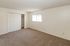Bright and spacious bedroom with plush carpet, large closet, and natural light streaming through the window.