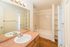 Bright and inviting bathroom with elegant fixtures, large mirror, and a soothing bathtub, perfect for relaxation.