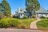 Charming suburban home surrounded by lush greenery and a well-maintained lawn, perfect for family living.
