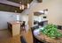 Inviting open-concept living space featuring a modern kitchen island, elegant dining area, and cozy lounge with vaulted wooden ceiling.