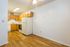 Inviting kitchen space with modern appliances and warm wooden cabinetry, complemented by elegant hardwood flooring and ample lighting.